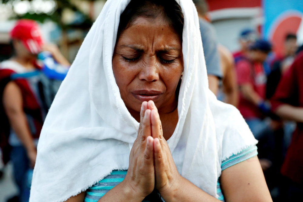 A migrant woman from El Salvador, part of a caravan traveling to the United States, prays during a stop Nov. 2, 2018, in Tecún Umán, Guatemala. (CNS/Reuters/Ueslei Marcelino) A migrant woman from El Salvador, part of a caravan traveling to the United States, prays during a stop Nov. 2, 2018, in Tecún Umán, Guatemala. (CNS/Reuters/Ueslei Marcelino)